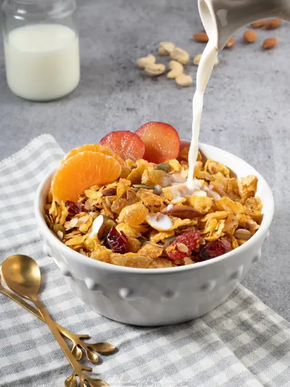 An action shot of milk being poured into a bowl of muesli. This dynamic image is more engaging than a static one and creates a sense of a fresh, ready-to-eat breakfast.