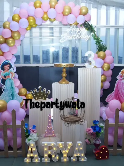 An outdoor princess party with a stunning view. The setup includes cutouts of Jasmine and Aurora.