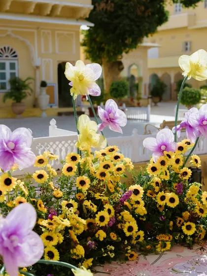 A close-up of the sunflower and oversized purple flower decorations, set against the beautiful architecture of Chomu Palace. This highlights our creative use of florals.