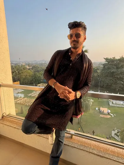 Taking a moment to chill on the balcony before a wedding gig in Daman. Dressed in a modern kurta, enjoying the view before the party begins.