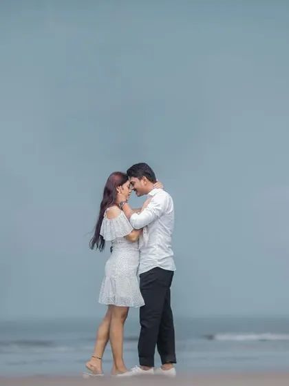 An intimate portrait against the vast, open ocean. The minimalist composition draws all attention to the couple's embrace.
