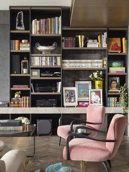 A close-up of the beautifully curated bookshelf in the Caitriona apartment, filled with art books, personal photos, and collected objects that tell the story of the homeowner.