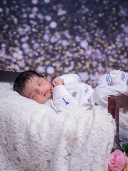 A starry night's dream. This photo captures a baby sleeping peacefully against a magical, glittering backdrop.