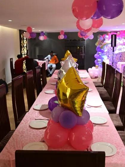 A close-up of a themed table centerpiece with star-shaped foil balloons. These small details help tie the entire event's decor together.
