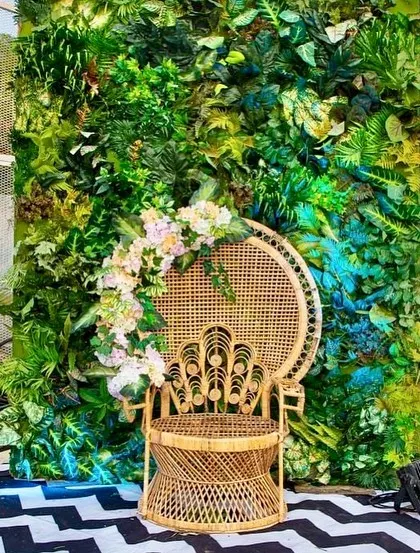 Another view of the peacock chair and green wall photo booth, a popular spot for guests at the 60th birthday party.