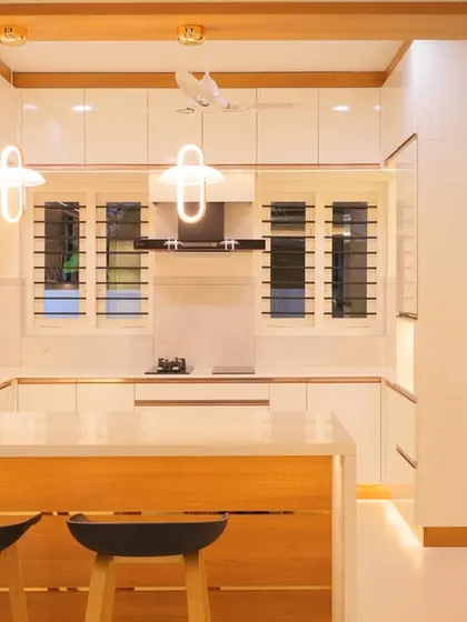 A bright and airy kitchen combining white and wood tones. The breakfast bar with stylish stools creates a casual dining spot, making the kitchen a social hub.