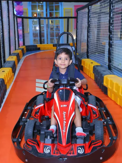 A young boy looks serious about his race, gripping the steering wheel and ready for adventure.