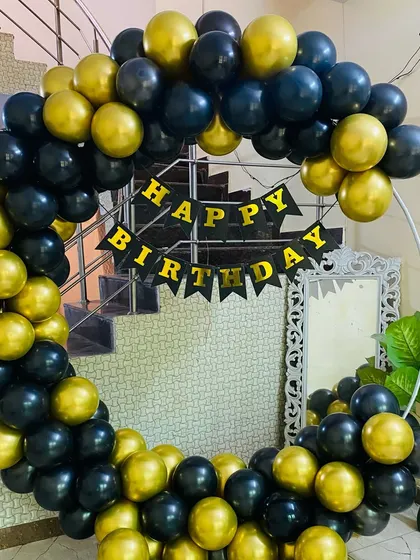 A simple and bold birthday balloon ring in black and gold, with a "Happy Birthday" banner in the center.