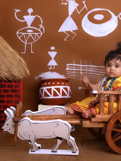 Another angle of our bullock cart setup, capturing the child's profile as they sit amidst the traditional props of the Janmashtami theme.