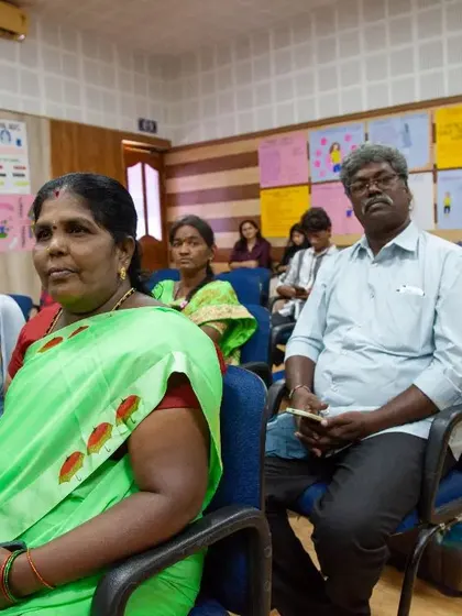 Parents and family members listen intently during the graduation ceremony. Their presence and support are a powerful testament to the impact of empowering young female athletes to become leaders.