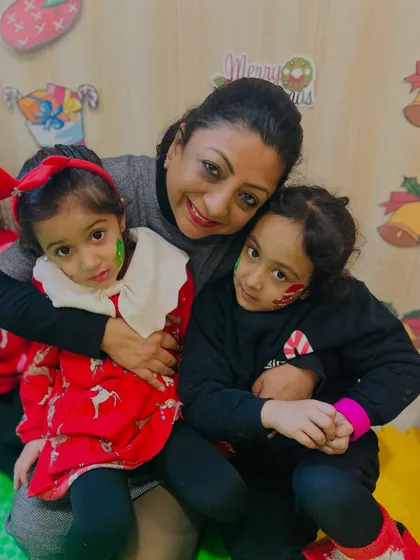 An instructor shares a hug with two children, capturing the warm and affectionate atmosphere of our club.