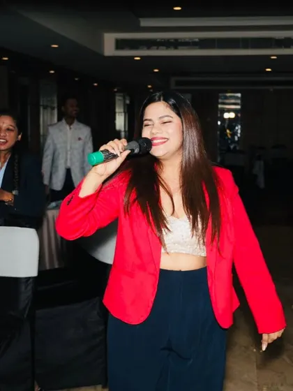 A joyful shot of me singing and interacting with the audience at their tables during the Skills Bazzar event.