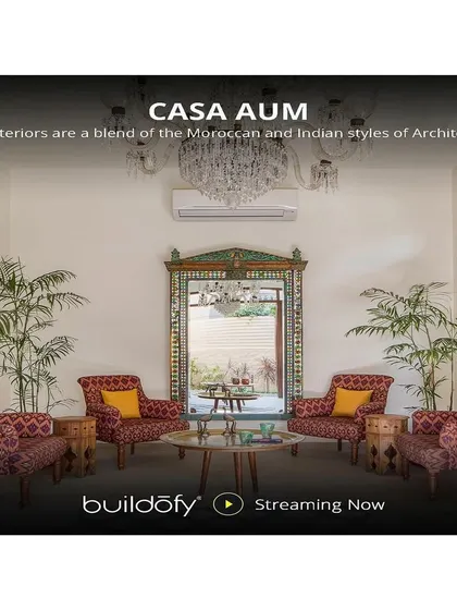 The interiors of Casa Aum are a blend of Moroccan and Indian styles. This formal seating area features patterned upholstery, an ornate mirror, and a grand chandelier, creating a space that is rich in cultural fusion.