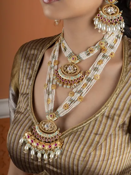 A detailed view of the layered pearl and Kundan necklaces. Each layer is designed to complement the others, creating a look of opulent elegance.