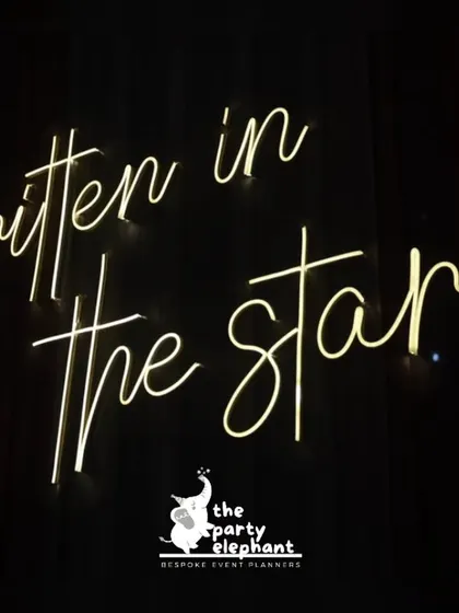A 'Written in the stars' neon sign against a dark backdrop. I use custom neon signs to add a modern, personal, and highly Instagrammable element to wedding receptions.