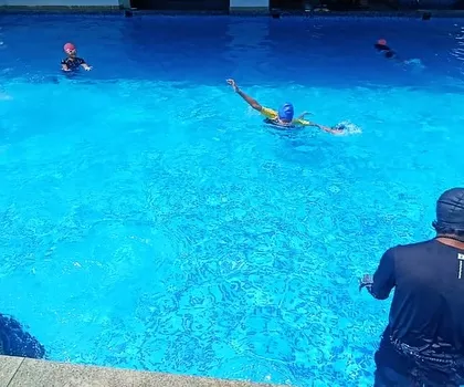 A coach provides in-water instruction, helping a young swimmer perfect their stroke and build confidence.