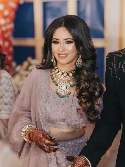 A candid moment from the reception. The bride's makeup is soft and elegant, perfect for mingling with guests.