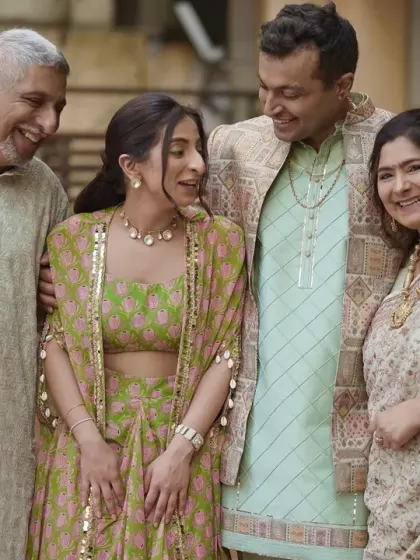 A candid moment of laughter and joy shared between the couple and their parents.