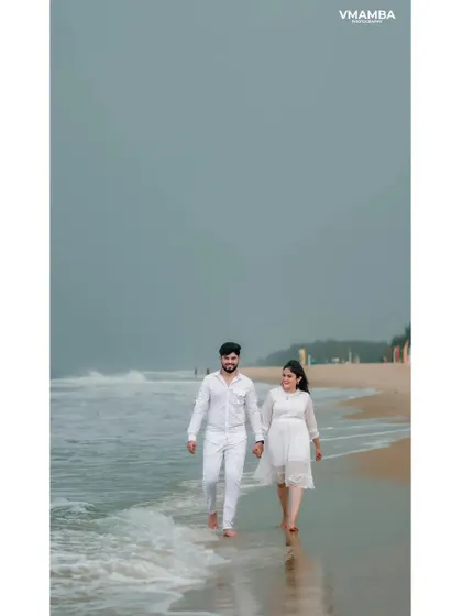 A vertical shot of a couple walking by the sea, capturing the peaceful and romantic mood of their beach pre-wedding shoot.
