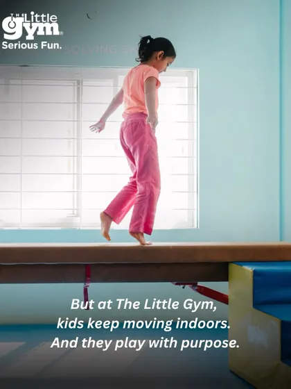 A girl confidently walks the balance beam. At The Little Gym, kids keep moving indoors and play with purpose, no matter the weather.