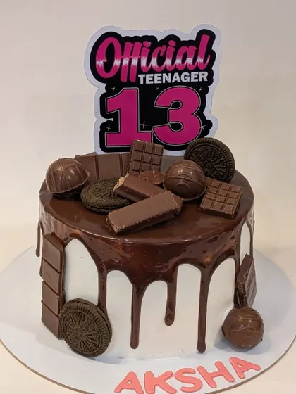 An "Official Teenager" cake for a 13th birthday. This fun chocolate drip cake is loaded with Oreos, KitKats, and other chocolate treats.