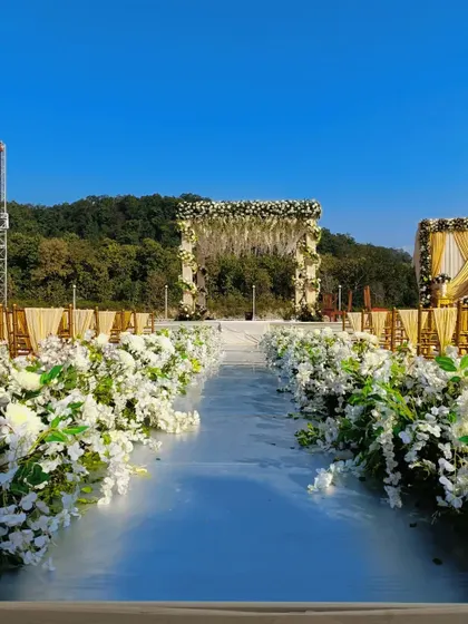 The pristine white aisle lined with lush white flowers, leading to a beautiful mandap overlooking the hills of Jim Corbett.