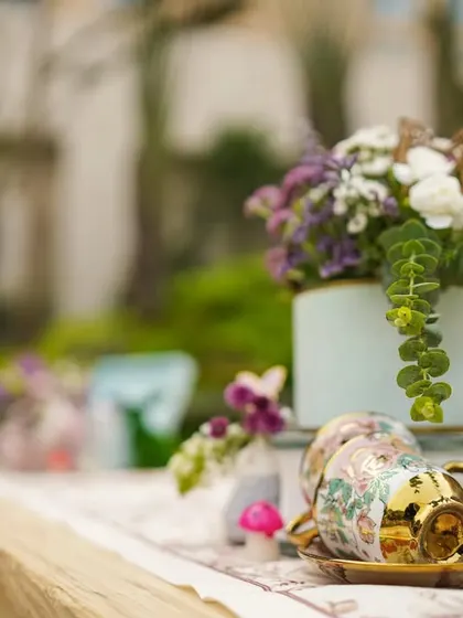 A golden teacup and other whimsical items used in the table centerpieces, perfectly capturing the "Mad Hatter's Tea Party" vibe.