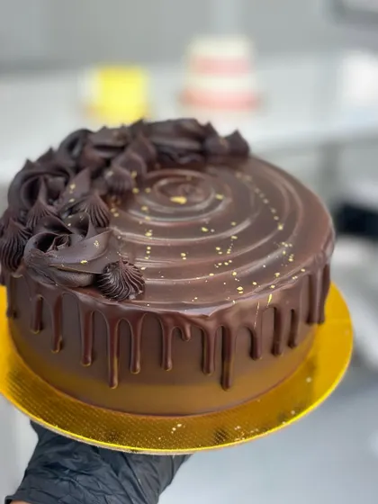 A close-up of a rich, decadent chocolate drip cake, one of the many popular designs we teach. You will learn to create this glossy ganache, master the drip technique, and pipe beautiful chocolate swirls for a truly professional finish.