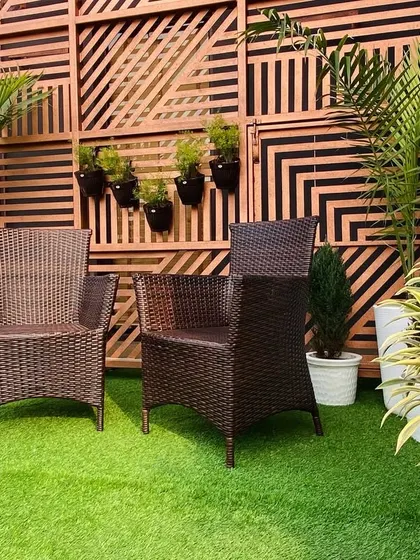 The full setup, with potted plants framing the seating area and hanging planters on the decorative screen.