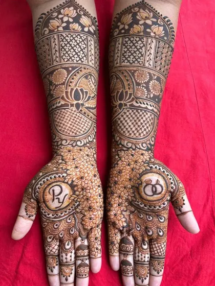 A lovely engagement mehendi design featuring the couple's initials and engagement rings within a floral mandala. It's a beautiful way to celebrate the beginning of a new journey.