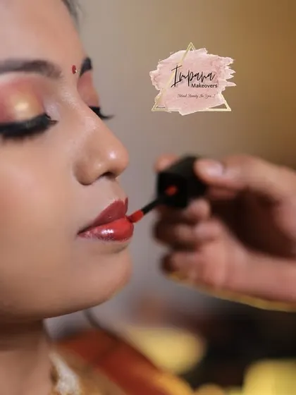 Applying the perfect shade of red lipstick to complete this bride's traditional look. I guide my students on how to choose and apply lip colors that complement their skin tone and the occasion.