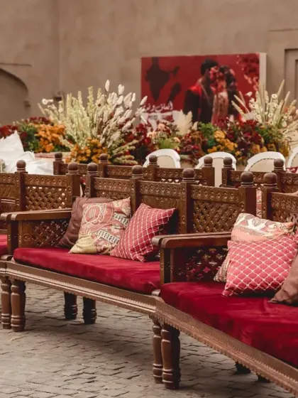 Traditional carved wooden seating with rich red cushions provided an authentic and comfortable experience for guests, perfectly complementing the heritage theme of the wedding decor.
