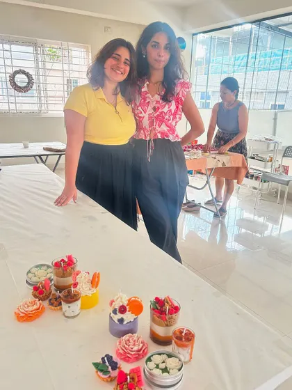 A repeat photo of two participants with their table of finished candles.