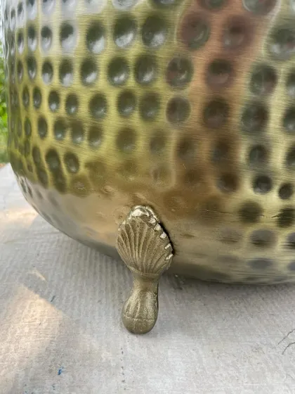 The detailed, shell-like design of the feet on our antique brass planter. This vintage-inspired touch adds a layer of elegance and sophistication.