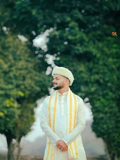 A serene outdoor portrait of the groom in a white and yellow traditional outfit. With his eyes closed, he seems to be soaking in the peaceful moments before the ceremony.
