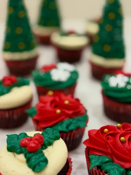 A close-up of my Christmas cupcakes, showing the detailed piping work on the Christmas tree and poinsettia designs.