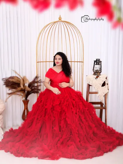 A romantic couple's portrait in our bohemian studio setup, with the mother-to-be in a stunning red ruffled gown.