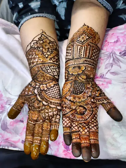 A classic bridal look with a mix of peacocks, geometric checks, and floral patterns, covering the hands and wrists.