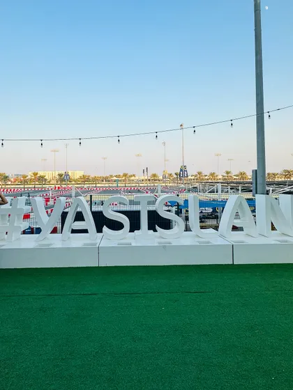 Posing with the #YasIsland sign. For this day, I opted for a casual look with a pink top, black pants, and white sneakers.