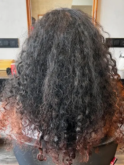 The before shot of a major curly hair transformation. This client was ready to embrace her curls and give them a new life with some color.