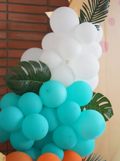 A close-up of a balloon arrangement showing how I incorporate artificial leaves to add a touch of green and texture, perfect for jungle or dinosaur themes.