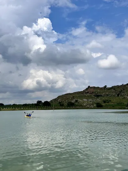 A lone kayaker paddling across a tranquil lake under a big sky. It's a perfect activity to connect with nature.