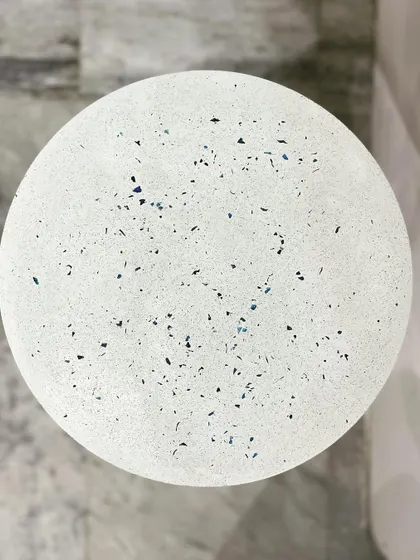 A top-down view of the minimal blue terrazzo tabletop. The subtle specks of blue add a touch of color and interest to the clean white surface.