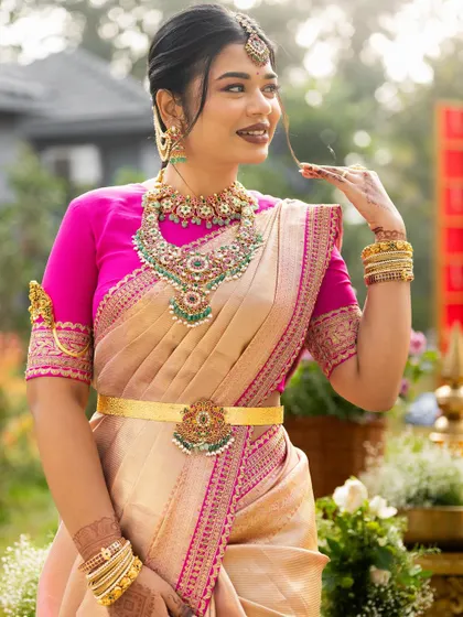 A close-up of the bride, showcasing her beautiful makeup and the intricate details of her pink embroidered blouse.