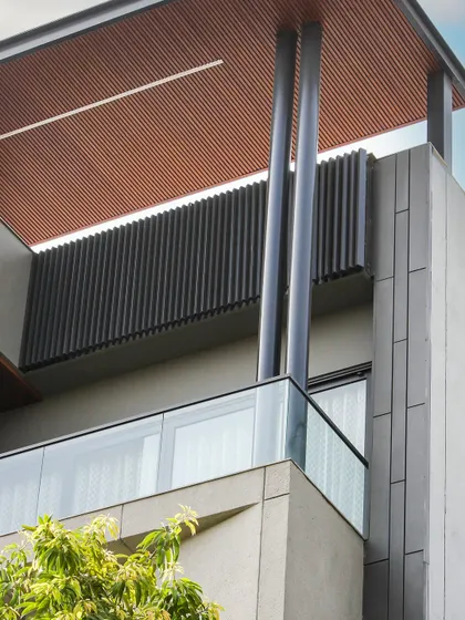 A close-up of the Akashneem Marg project, highlighting the strong vertical columns and the texture of the wood-look ceiling panels. The design is simple, modern, and sophisticated.