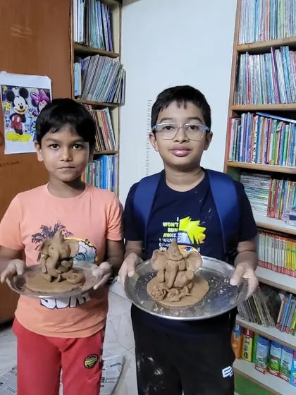Two boys showing off their handmade Ganesha idols. The pride and sense of accomplishment they feel is what makes these community events so special.