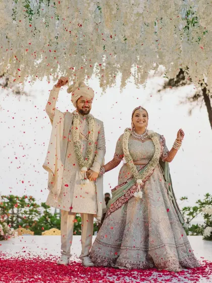 A moment of pure celebration as the couple is showered with petals under their beautiful floral mandap.
