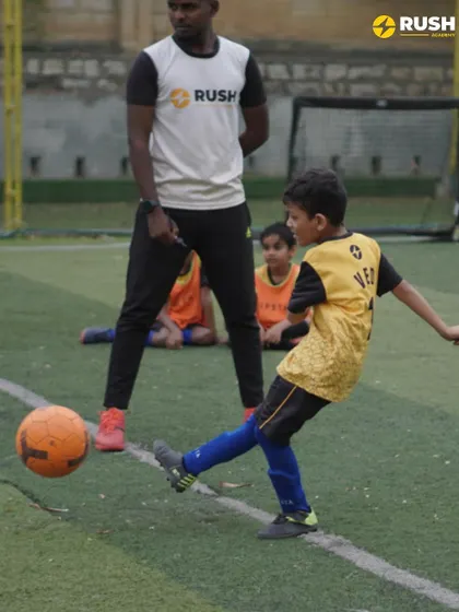 A coach watches closely as a player practices his shooting form. This direct supervision ensures players receive immediate and constructive feedback.