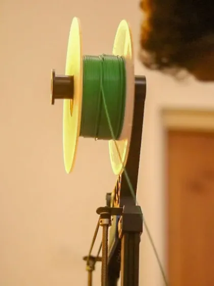 A spool of green PLA filament, the biodegradable and eco-friendly material we use for our 3D printing projects. We are committed to sustainable making.