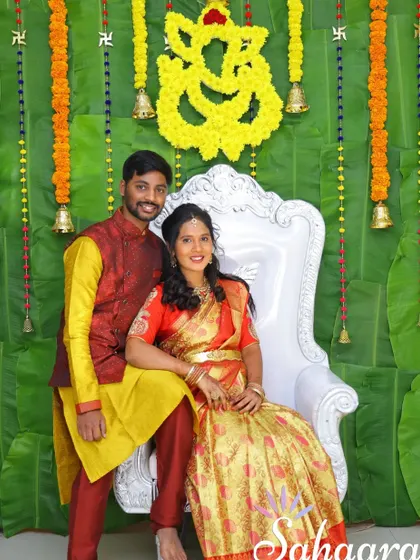 A classic and traditional baby shower setup. The backdrop of fresh banana leaves, marigold garlands, and brass bells creates an auspicious and beautiful setting for the mother-to-be.